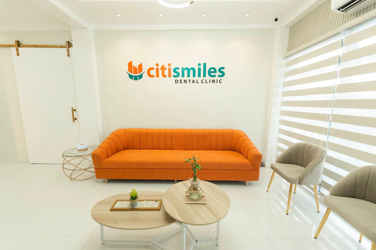 Waiting area with an orange sofa at the Citismiles clinic in Balanga City